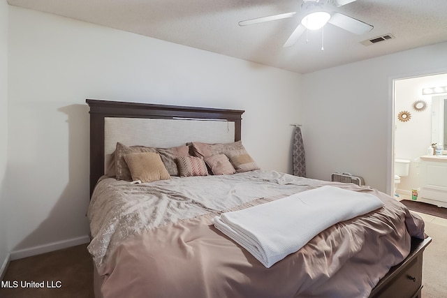 carpeted bedroom with ensuite bath and ceiling fan