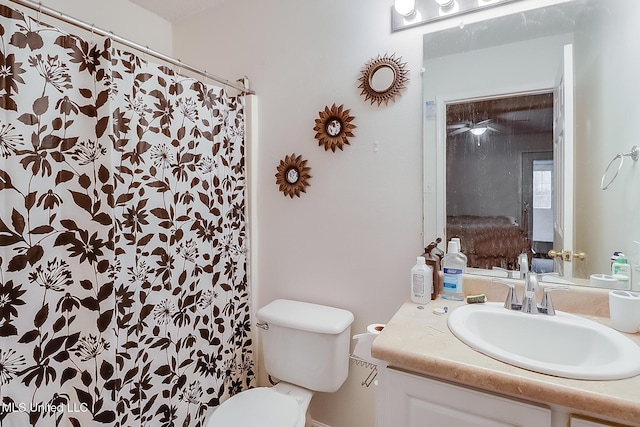 bathroom featuring toilet, vanity, and a shower with shower curtain