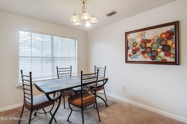 dining area with carpet floors and a notable chandelier