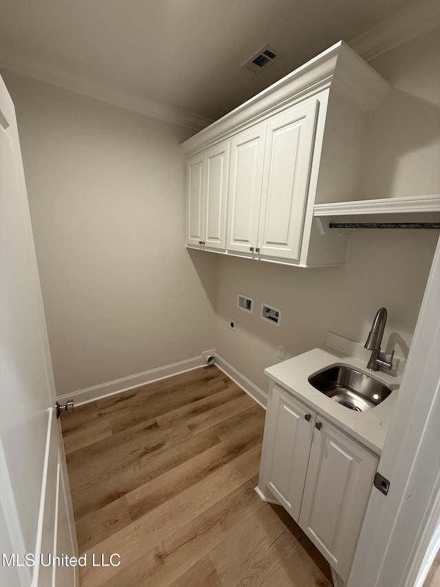 409 Butternut Dr, Canton, MS 39046 - laundry area with washer hookup, ornamental molding, cabinet space, electric dryer hookup, and light wood-style floors