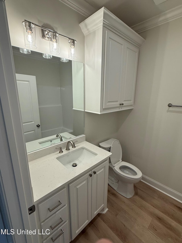 409 Butternut Dr, Canton, MS 39046 - bathroom with crown molding, wood finished floors, vanity, toilet, and baseboards