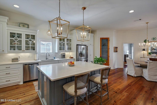 kitchen with visible vents, a sink, appliances with stainless steel finishes, an inviting chandelier, and decorative backsplash