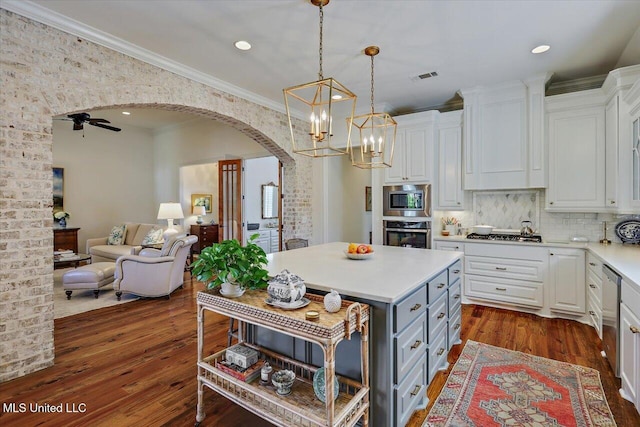 kitchen featuring arched walkways, white cabinets, gray cabinetry, and stainless steel appliances