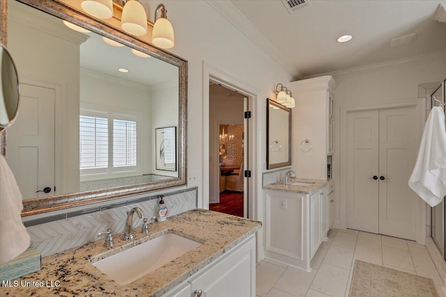 full bath with two vanities, ornamental molding, visible vents, and a sink