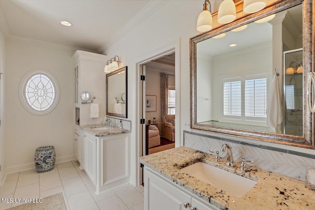 bathroom featuring ornamental molding, a stall shower, two vanities, and a sink