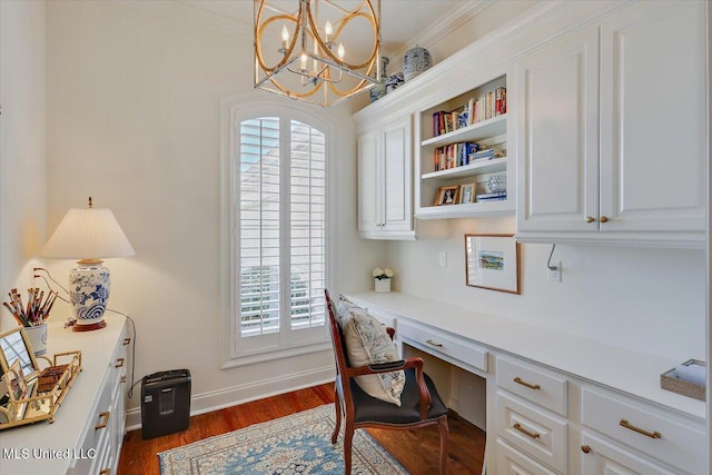 home office with baseboards, crown molding, dark wood-style flooring, and built in study area