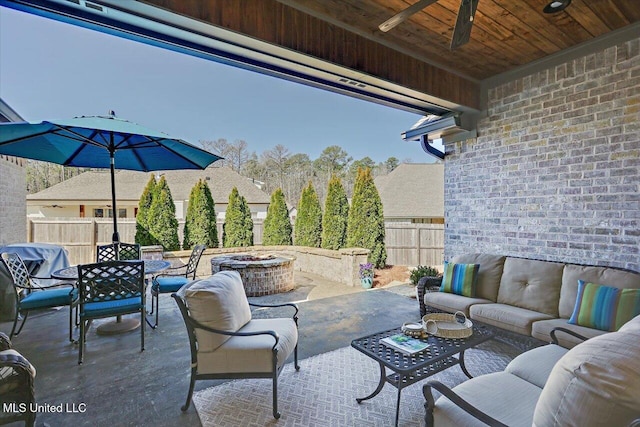 view of patio / terrace featuring an outdoor living space with a fire pit, outdoor dining area, and fence