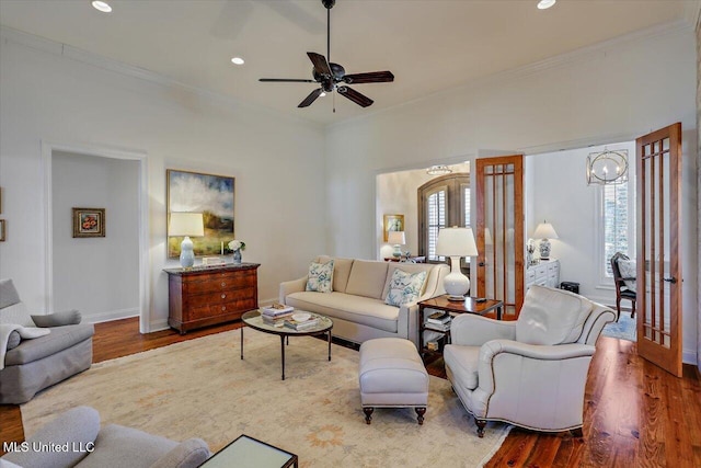 living room featuring recessed lighting, wood finished floors, baseboards, and ornamental molding