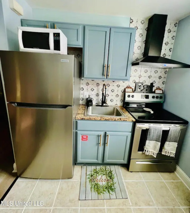 kitchen featuring wall chimney exhaust hood, sink, light tile patterned floors, appliances with stainless steel finishes, and tasteful backsplash