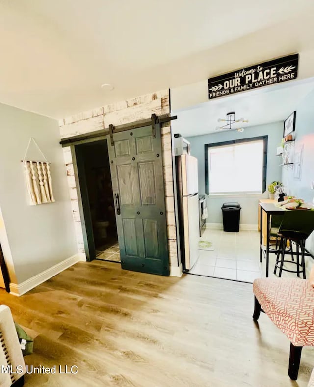 corridor featuring a barn door and light hardwood / wood-style floors