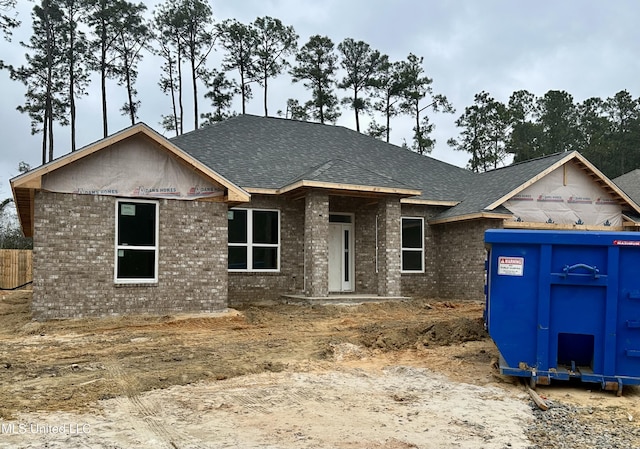 view of front of house featuring brick siding and a shingled roof