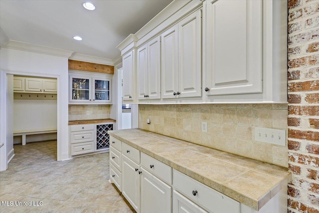 kitchen featuring light tile patterned flooring, recessed lighting, tile counters, white cabinets, and tasteful backsplash