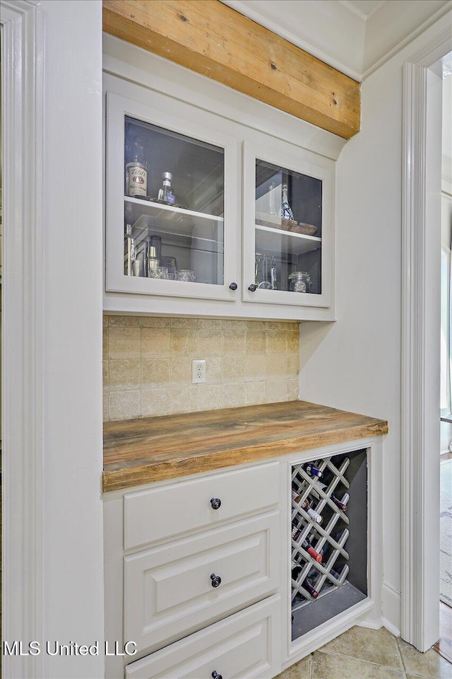 bar with tasteful backsplash, a bar, and light tile patterned flooring
