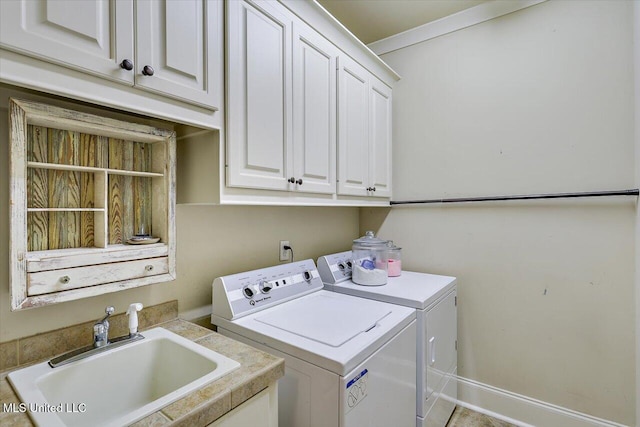 washroom featuring washing machine and clothes dryer, a sink, and cabinet space