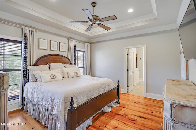 bedroom featuring multiple windows and a tray ceiling