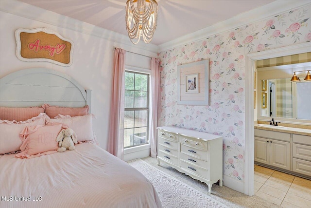 bedroom featuring a sink, connected bathroom, an inviting chandelier, wallpapered walls, and light tile patterned flooring