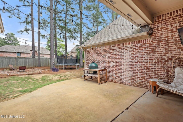 view of patio / terrace with fence private yard and a trampoline