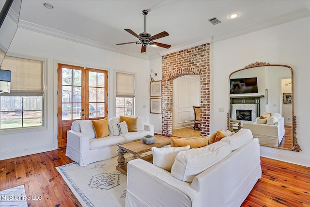 living room with visible vents, wood-type flooring, a fireplace, and french doors