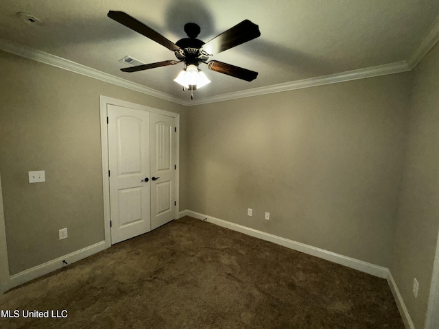 unfurnished bedroom featuring ornamental molding, a closet, and dark colored carpet