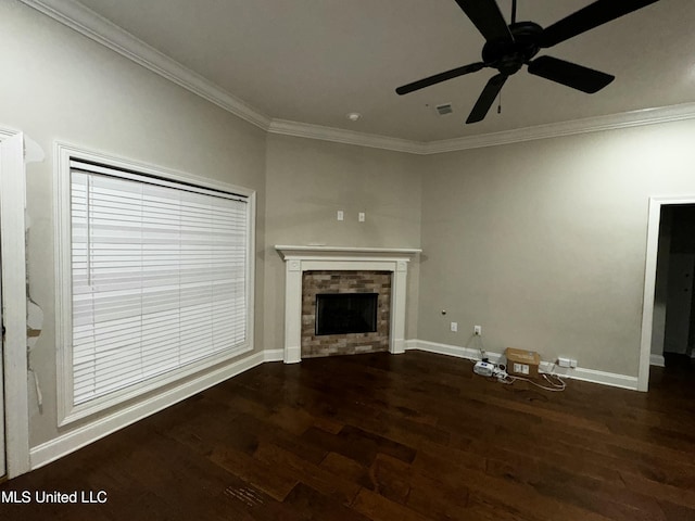 unfurnished living room with ornamental molding, a brick fireplace, dark wood-type flooring, and ceiling fan