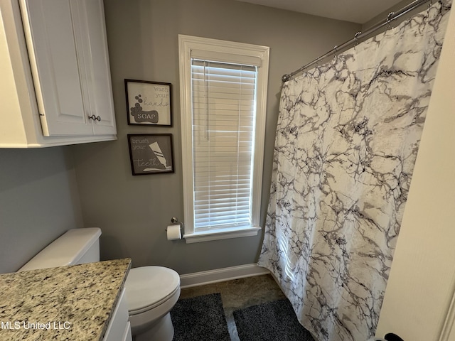 bathroom featuring vanity, toilet, and walk in shower