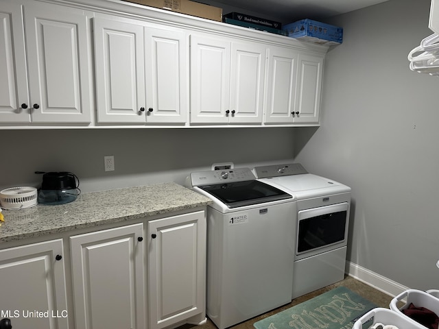 washroom featuring cabinets and washing machine and clothes dryer