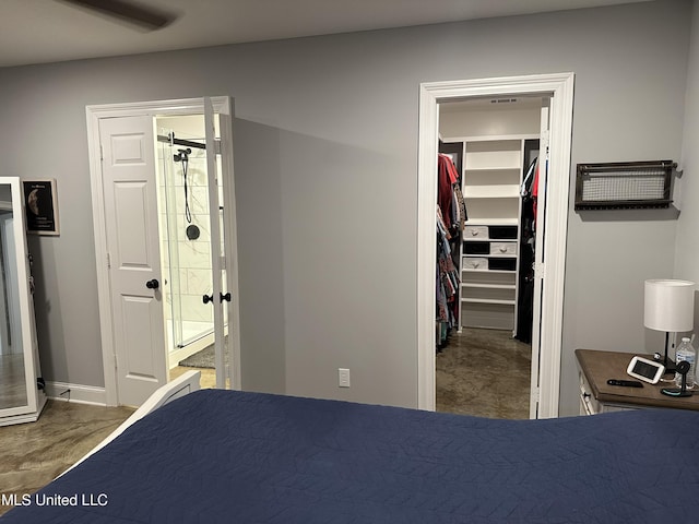 unfurnished bedroom featuring ceiling fan, a spacious closet, ensuite bathroom, and a closet