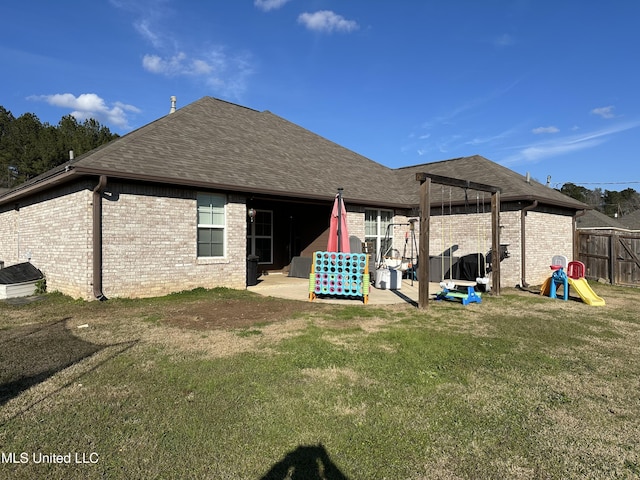 rear view of house featuring a lawn and a patio