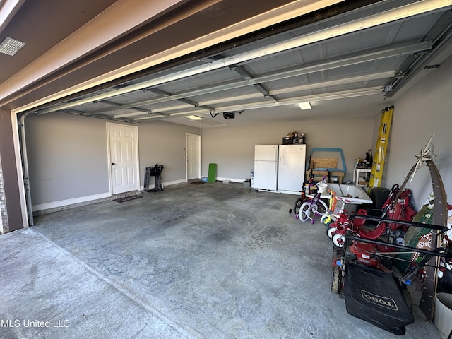 garage with a garage door opener and white refrigerator