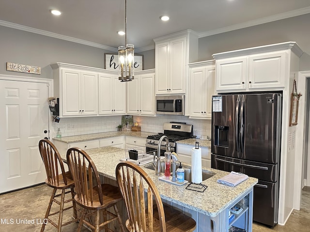 kitchen featuring a center island with sink, white cabinets, light stone counters, and stainless steel appliances