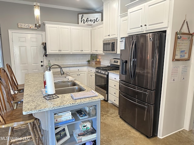 kitchen featuring appliances with stainless steel finishes, a kitchen island with sink, sink, white cabinetry, and hanging light fixtures