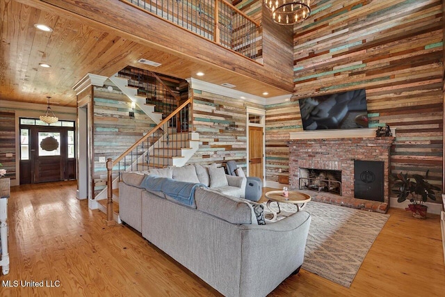 849 Athens Rd, Mendenhall, MS 39114 - living room with a towering ceiling, wooden walls, stairs, wood finished floors, and a fireplace