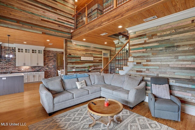 849 Athens Rd, Mendenhall, MS 39114 - living area with wood walls, light wood-style flooring, stairway, and a high ceiling