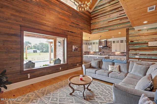 849 Athens Rd, Mendenhall, MS 39114 - living room with wooden walls, a high ceiling, a chandelier, and wood finished floors