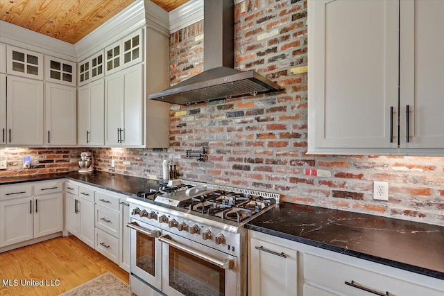 849 Athens Rd, Mendenhall, MS 39114 - kitchen with wall chimney range hood, double oven range, glass insert cabinets, white cabinetry, and light wood-type flooring