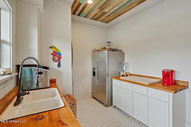849 Athens Rd, Mendenhall, MS 39114 - kitchen with stainless steel fridge, white cabinets, ornamental molding, wooden ceiling, and light countertops