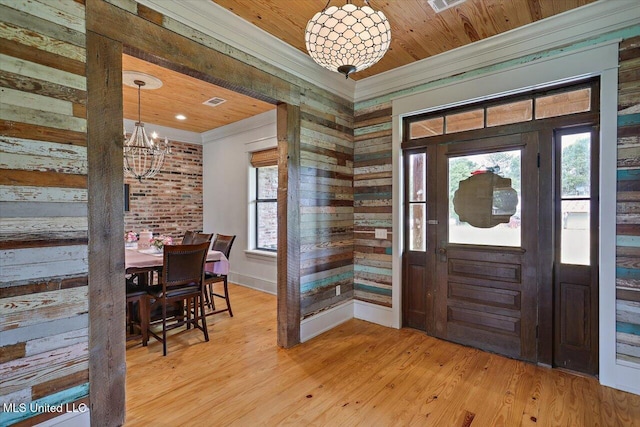 849 Athens Rd, Mendenhall, MS 39114 - entryway featuring a chandelier, ornamental molding, light wood-style floors, and wooden walls
