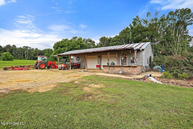849 Athens Rd, Mendenhall, MS 39114 - view of front of house with a garage, a front yard, an outdoor structure, and a metal roof