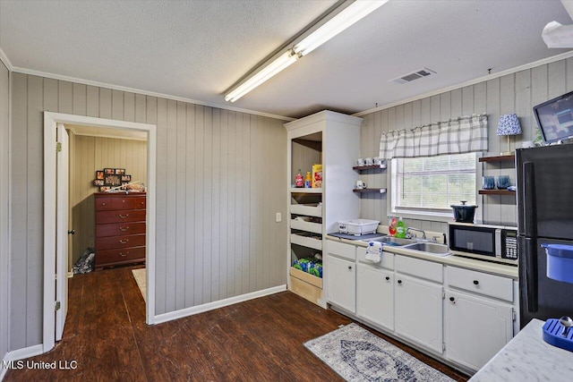 849 Athens Rd, Mendenhall, MS 39114 - kitchen with open shelves, dark wood-type flooring, ornamental molding, white cabinets, and freestanding refrigerator