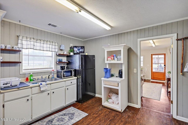 849 Athens Rd, Mendenhall, MS 39114 - kitchen with open shelves, freestanding refrigerator, stainless steel microwave, dark wood-style floors, and white cabinetry
