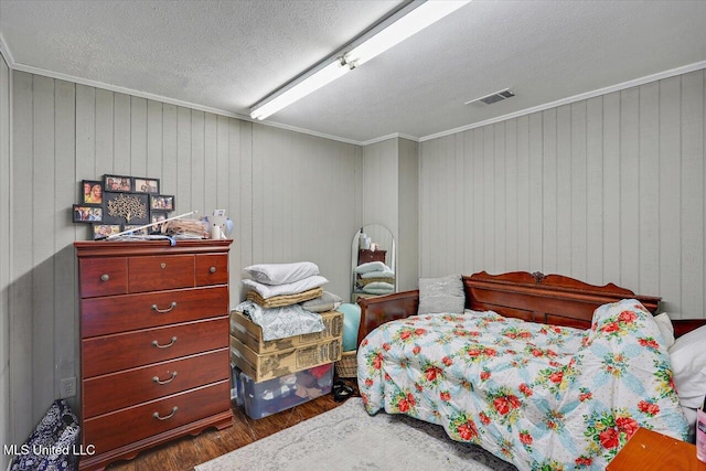 849 Athens Rd, Mendenhall, MS 39114 - bedroom with dark wood-type flooring, ornamental molding, wood walls, and a textured ceiling