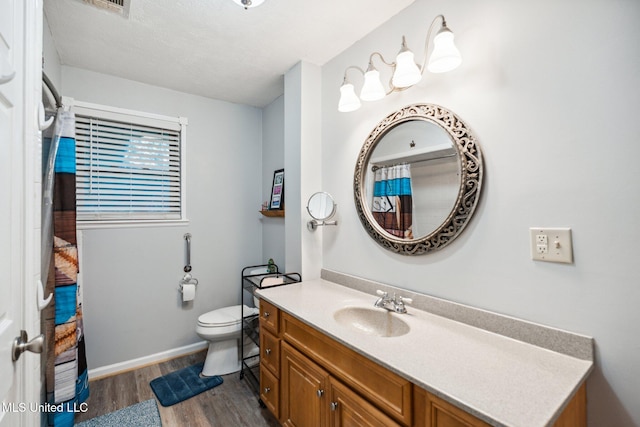 bathroom featuring wood-type flooring, vanity, and toilet