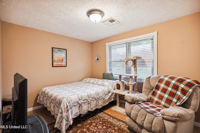 bedroom featuring wood-type flooring and a textured ceiling