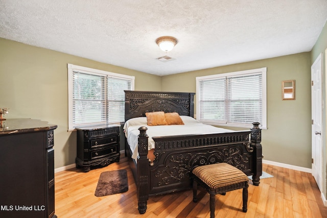 bedroom featuring a textured ceiling and light wood-type flooring