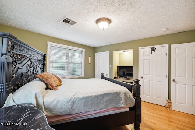 bedroom featuring hardwood / wood-style floors and a textured ceiling