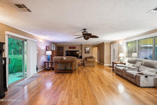 living room featuring a wealth of natural light, a textured ceiling, and light wood-type flooring