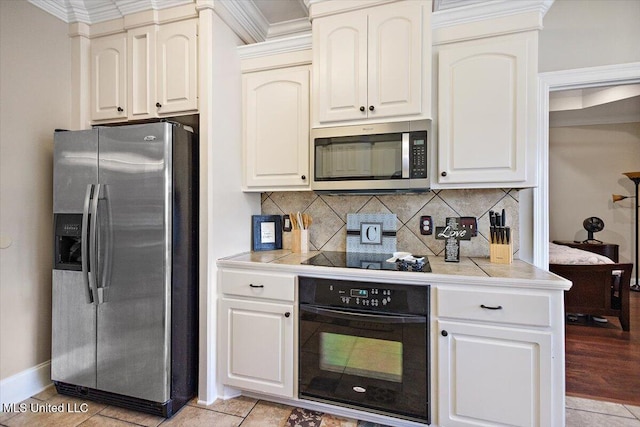 kitchen featuring tile counters, crown molding, backsplash, and black appliances