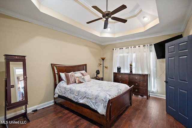 bedroom with dark wood-style floors, baseboards, a raised ceiling, and crown molding