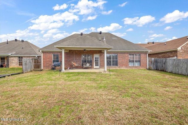 back of property featuring a fenced backyard, a patio, and a lawn