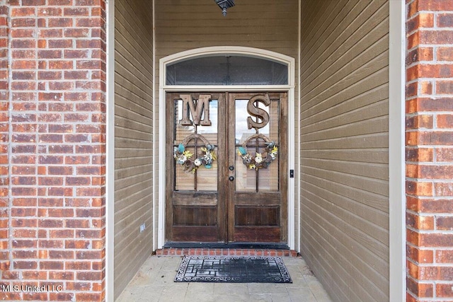 view of exterior entry with french doors and brick siding